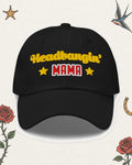 Headbangin' Mama Embroidered Dad Hat in Black, product view on pale ivory with faded colored tattoo flash.