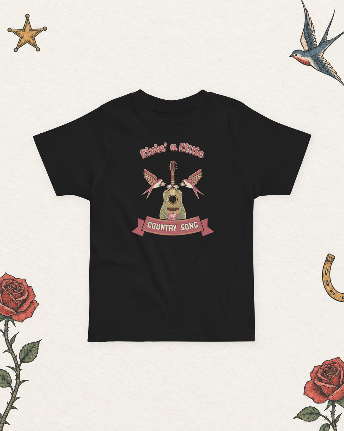 Livin' a Little Country Song Toddler T-Shirt in Black, product view on pale ivory with faded colored tattoo flash.