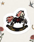 Rose Rocking Horse Sticker in Red / Black / Gold, product view on pale ivory with faded colored tattoo flash.