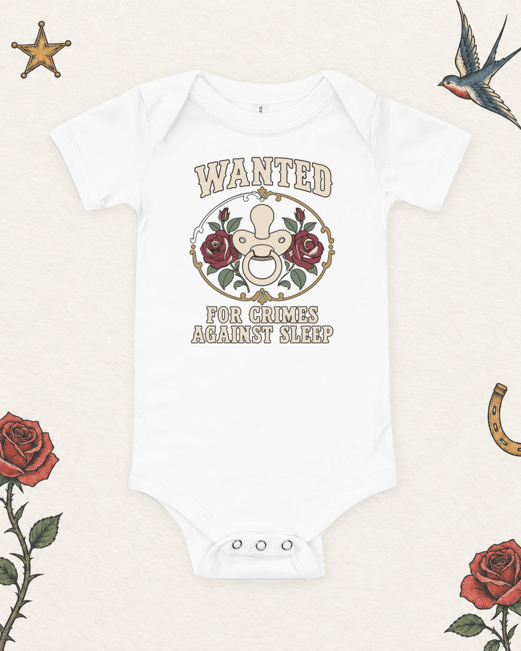 Wanted: For Crimes Against Sleep Baby Bodysuit in White, product view on pale ivory with faded colored tattoo flash.