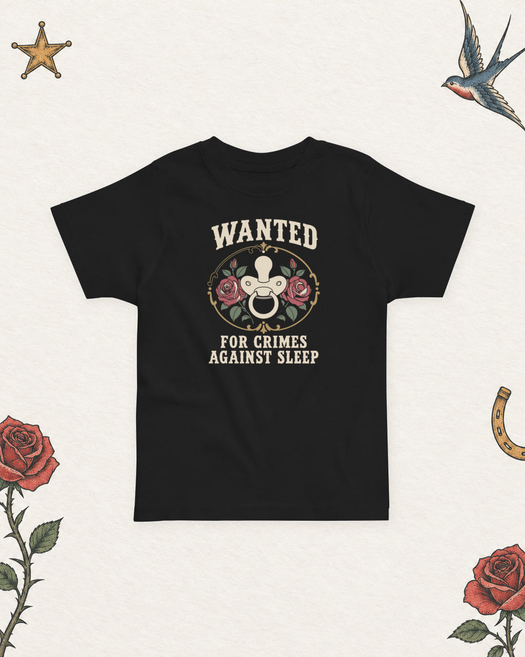 Wanted: For Crimes Against Sleep Toddler Tee in Black, product view on pale ivory with faded colored tattoo flash.